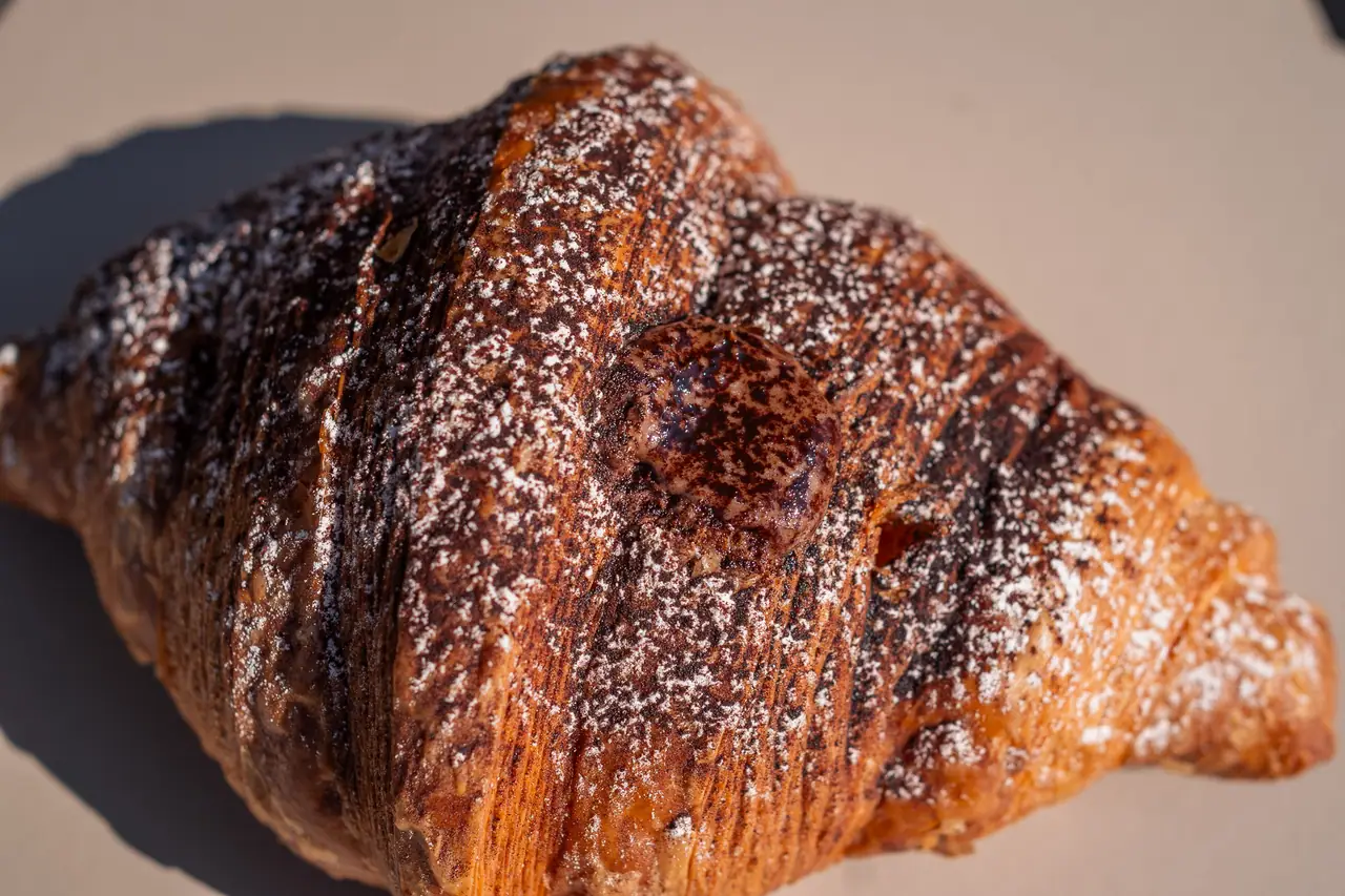 Un cornetto al burro sul cartoncino della pasticceria