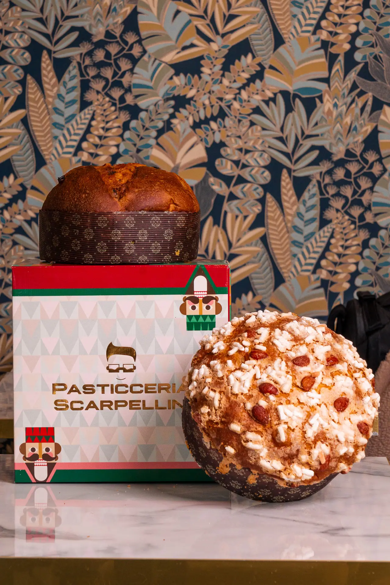 Panettone artigianale con la sua scatola, davanti alla carta da parati
