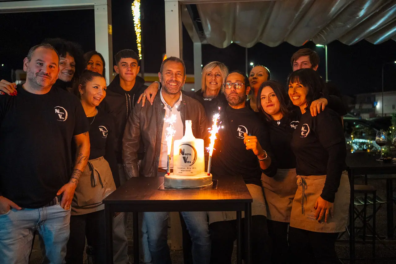 Lo staff riunito dietro una torta con le scintille