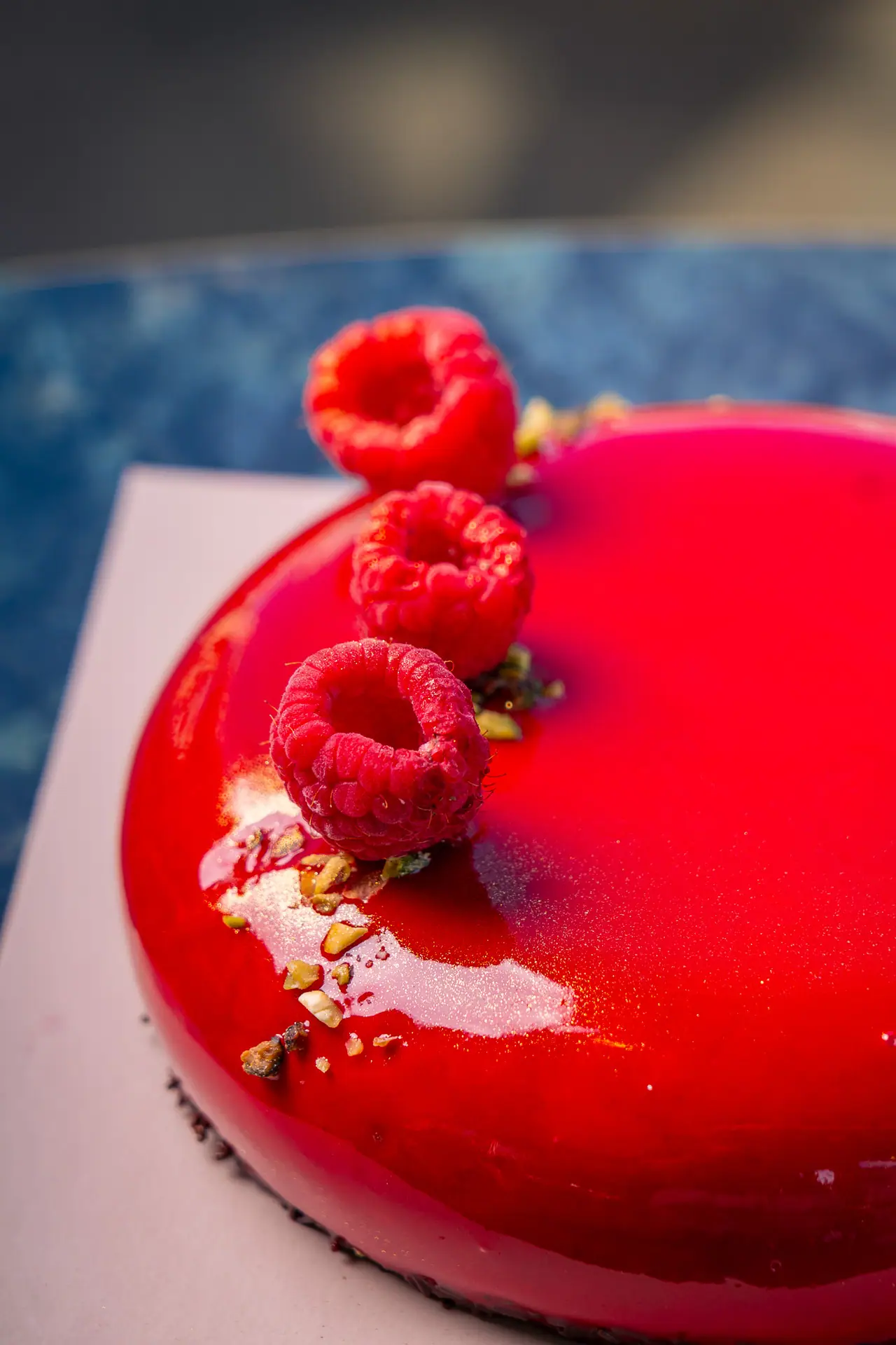 Torta moderna con glassa rossa lucida e lamponi